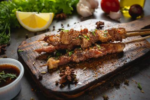 beberapa tusuk sate dengan bumbu sichuan pepper ada di atas talenan kayu