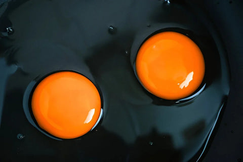 2 buah kuning telur omega diatas wajan