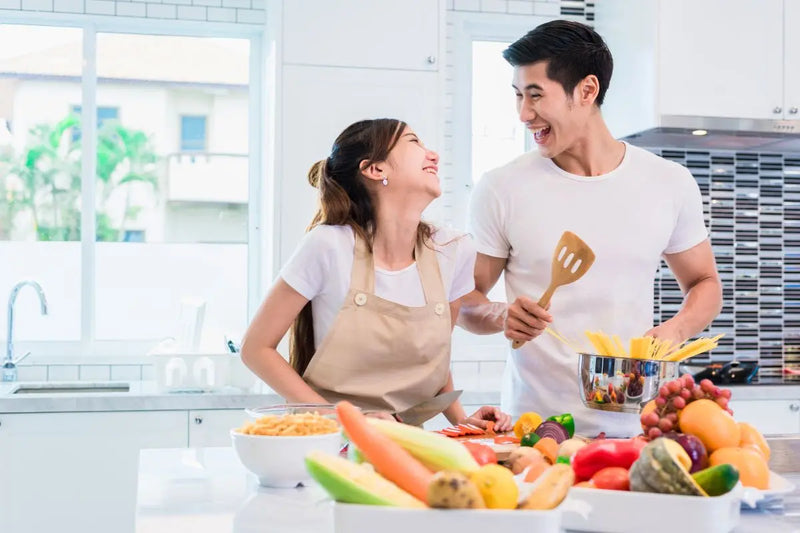 Pasangan bahagia memasak bersama di dapur