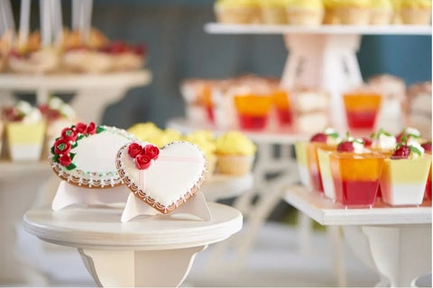 Kue kering berbentuk hati berhias mawar merah di atas meja