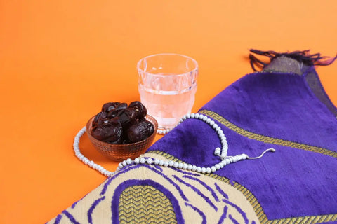 sajadah, tasbih, segelas air putih, dan semangkuk kurma untuk buka puasa