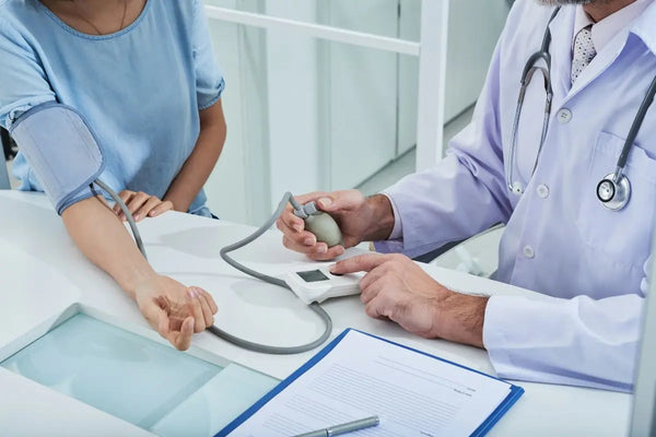 dokter yang sedang memeriksa tekanan darah pasien