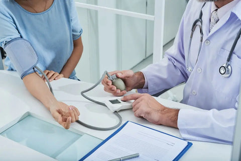 dokter yang sedang memeriksa tekanan darah pasien