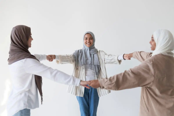 tiga orang muslim yang sedang berpegangan tangan