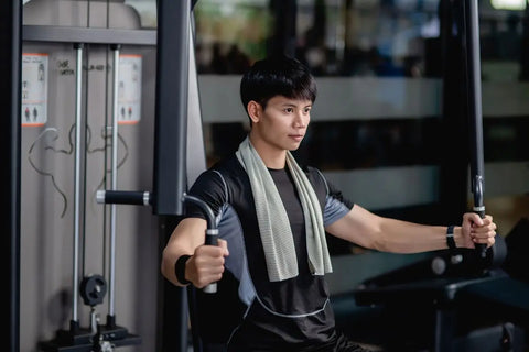 orang yang sedang latihan di gym sambil membawa barbel