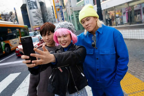 Tiga orang berfoto di depan landmark 