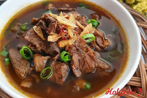 semangkuk rawon dengan kecambah, telur, dan jeruk nipis